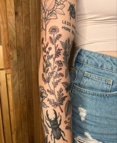 a woman's arm with tattoos and flowers on it