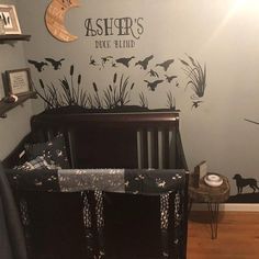 a baby's room decorated in black and white with bats on the wall, along with a crib