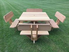 a wooden table and benches sitting in the grass