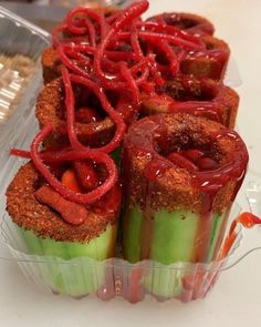 some food is in a plastic container on the table and it looks like they are made out of vegetables