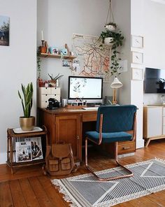 a living room with a desk, chair and computer on the table in front of it