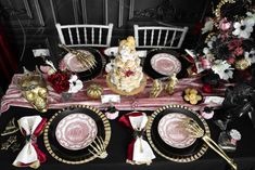 the table is set with black and white plates, silverware, and red napkins