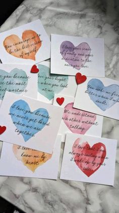 six cards with hearts and the words i love you in different languages, all lined up on a marble surface