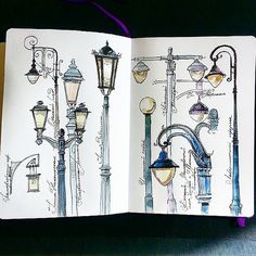 an open notebook with drawings of street lights and lamps on it's pages,