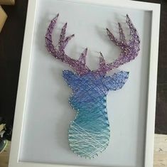 a string art deer head is displayed in a white frame