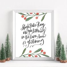 a white framed print with red berries and green leaves on it next to evergreen trees