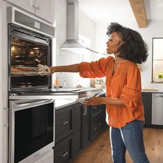 a woman opening the oven door to see what's cooking in her home kitchen