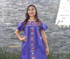 "This lovely dress was handmade in Mexico. The beautiful colorful flowers were embroidered by hand, so each one is unique. You will love wearing this comfortable cotton dress with short sleeves. It is perfect for a hot summer day. This dress comes just above or below the knee, depending on how tall you are. It has a square neckline and cute little puffy sleeves. The measurements on this dress are: Medium: 19-20\" wide Large: 21\"-22\" wide XLarge: 23\"-24\" wide XXLarge: 25\"-26\" About Our Item Purple Traditional Short Sleeve Dress, Traditional Purple Short Sleeve Dress, Traditional Purple Summer Dress, Multicolor Dresses With Embroidered Border And Short Sleeves, Traditional Purple Dresses For Festivals, Traditional Purple Festival Dress, Multicolor Dress With Embroidered Border And Short Sleeves, Purple Embroidered Dress For Summer, Multicolor Short Sleeve Dress With Embroidered Border