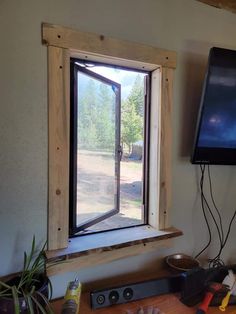 a flat screen tv mounted to the side of a wall in front of a window