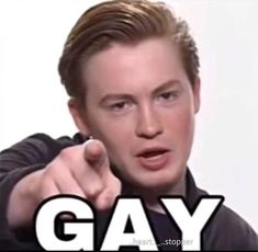 a man pointing at the camera with text saying gay