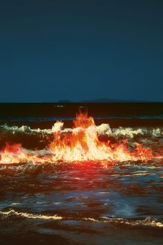 a fire hydrant in the middle of an ocean with water splashing around it