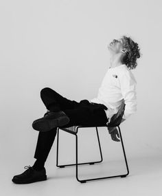 a young man sitting on top of a chair