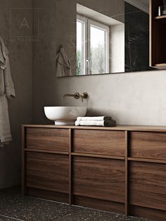 a bathroom sink sitting under a mirror next to a wooden cabinet with towels on it