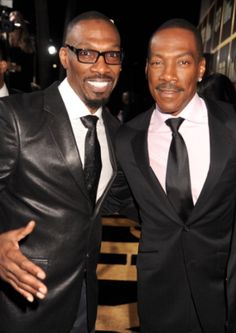 two men in suits posing for the camera