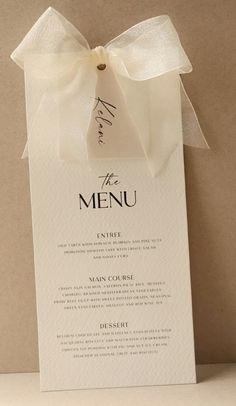 a menu with a white ribbon tied around it