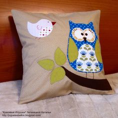 a pillow with an owl on it sitting on a bed