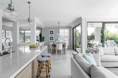 a kitchen and living room are shown in this modern style home, with white walls