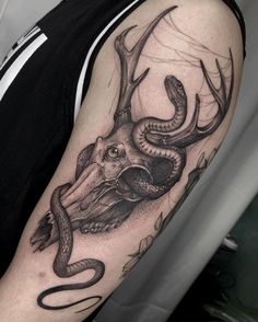 a man's arm with a deer head and snake on it