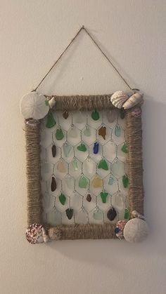 a wall hanging with sea glass and shells