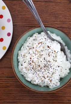 a bowl filled with mashed potatoes on top of a table next to a plate