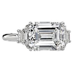 an emerald - cut diamond ring with three baguets on the shoulders and sides