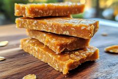 several pieces of food sitting on top of a wooden cutting board next to sliced almonds