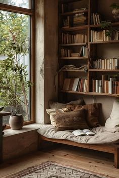 a window seat with bookshelves and plants in the corner, next to a potted plant