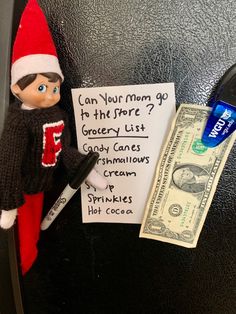 an elf with a note attached to the back of a refrigerator door next to money