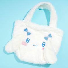 Carry your travel essentials using this kawaii handbag! It's made from fluffy material and showcases Cinnamoroll's face with embroidered ribbons and 3D ears. Features a snap-button closure Cute Plush School Bags, White Harajuku Bag With Cute Design, Kawaii White Bag With Removable Pouch, Kawaii Plush School Bag, White Kawaii Bag With Removable Pouch, White Kawaii Bags, Kawaii Plush Bags For Everyday Use, Playful White Bag With Cute Design, Cute White Shoulder Bag With Cute Design