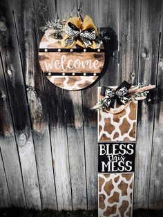 a giraffe print welcome sign hanging on the side of a wooden fence next to a door