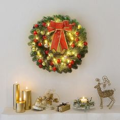 a christmas wreath on a mantle with candles