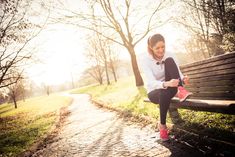 a woman sitting on a park bench reading a book