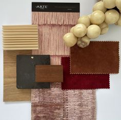 some different types of rugs and colors on a table with a plant in the middle