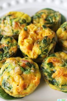 small muffins with spinach and cheese are on a white plate, ready to be eaten