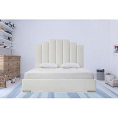 a white bed sitting in a bedroom on top of a blue and white striped rug