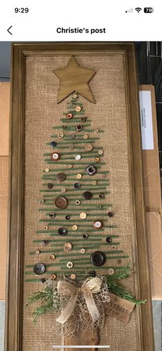 a christmas tree made out of buttons and burlock is displayed in a frame