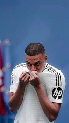 a man standing in front of a flag holding his hands together