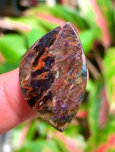 a close up of a person's finger holding a rock in their left hand