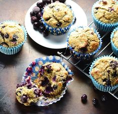 blueberry muffins cooling on a rack next to fresh blueberries and cranberries