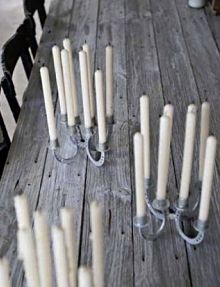 there are many candles that are on the wooden table and one candle is turned upside down