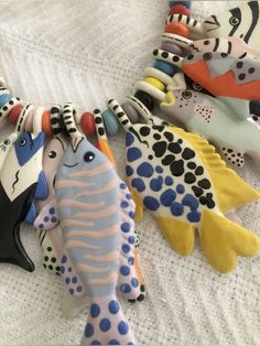 several ceramic fish are laying on a bed