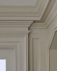 an empty room with white walls and moldings