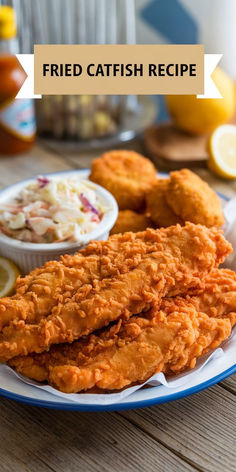 fried fish is served on a plate with coleslaw and lemons in the background