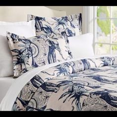 an image of a bed with blue and white comforter set in the middle of it