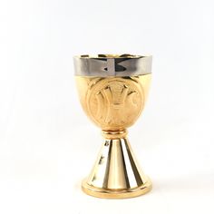 a gold and silver cup with an emblem on the side is sitting in front of a white background