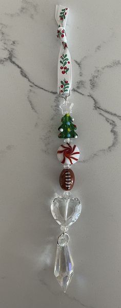 a white marble counter top with a glass bead christmas ornament hanging from it's side