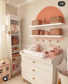 a baby's room with white furniture and pink accents on the walls, along with shelves filled with toys