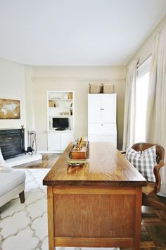 a living room filled with furniture and a wooden table in front of a fire place