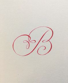 the letter b is drawn in red ink on white paper with a black pen next to it