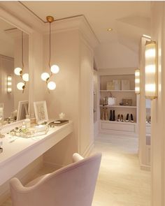 a room with a vanity, mirror and lights on the wall next to each other